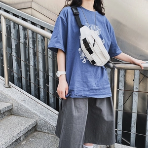 Detail der weißen Canvas-Umhängetasche mit Multi-Pocket-Design und schwarzen Schnallen