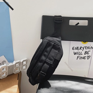 Detail der schwarzen Segeltuch-Brusttasche mit verstellbarem Gurt und Steckverschluss