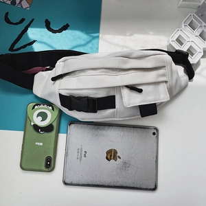 Detailansicht der weißen Segeltuch-Brusttasche mit schwarzen Gurten und Schnallentaschen