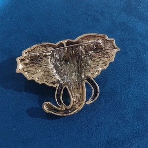 Vintage elephant head brooch in gold tone with textured metal back and pin closure