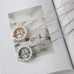 Chic gold and silver pearl buckle necklaces displayed on an open magazine backdrop