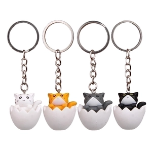 Detailed view of four 3D cartoon cats sitting in eggshells as decorative keychains