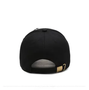 Rear view of black cotton baseball cap showing adjustable bronze metal buckle and six panels