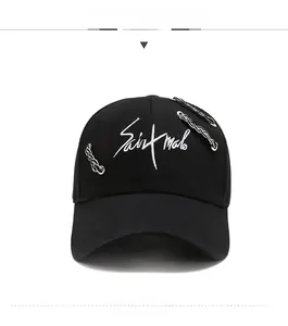 Close-up of black cotton baseball cap featuring white embroidery and silver metal chain detail