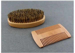 Close-up of wooden beard brush with boar bristles and dual-sided styling comb