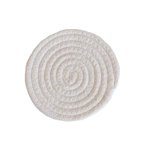 Detailed top view of a round beige woven cotton coaster with spiral braided texture