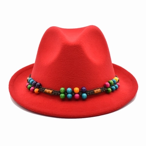 Détail du chapeau fedora rouge avec bande tressée bohème et perles colorées