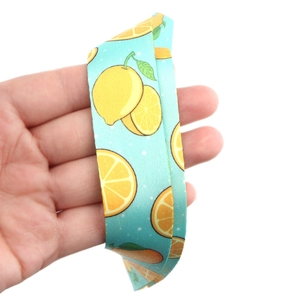 Close-up of light blue fruit phone lanyard with yellow lemon print and white polka dots