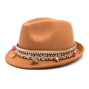 Detailed close-up of brown wool felt fedora with colorful bohemian tasseled ribbon and shells