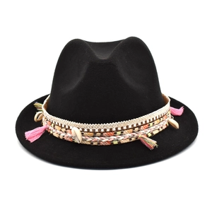 Detail of black wool fedora hat featuring colorful bohemian woven band and seashell charms