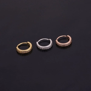 Detail of silver, gold, and rose gold hoop earrings with sparkling zircon inlay