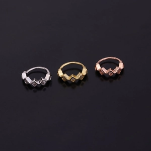 Detailed view of wave-shaped micro-pave zircon rings in silver, gold, and rose gold finish