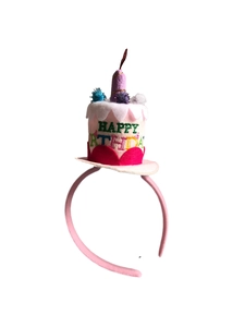 Close-up of pink Happy Birthday headband with felt cake, colorful pom-poms and candle