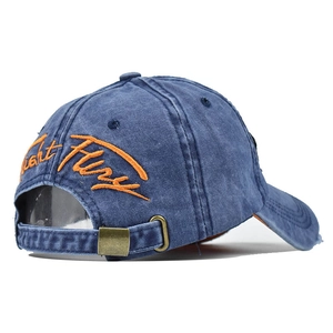 Detail of adjustable metal buckle and yellow Light Fury embroidery on blue washed cap