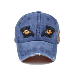 Washed dark blue baseball cap with cartoon eye embroidery and vintage distressed details