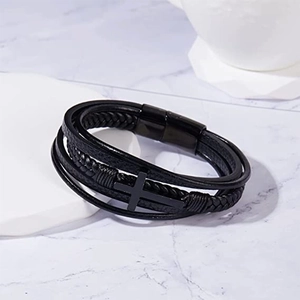 Detail of black multi-layer braided leather bracelet with magnetic clasp and cross