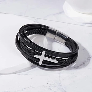 Close-up of triple-layered black braided leather bracelet with silver cross and magnetic clasp
