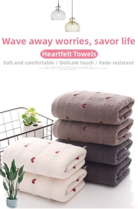 Detail of soft heart-patterned cotton towels neatly stacked in a decorative basket
