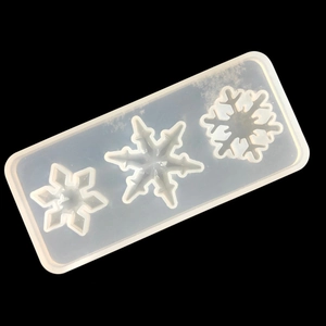 Detailed view of translucent silicone mold featuring three unique snowflake shapes for DIY resin