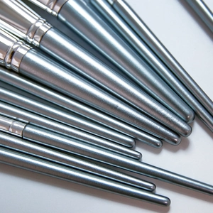 Set of makeup brushes with metallic blue-grey handles and silver ferrules on white background