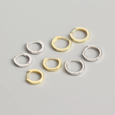 Detail view of gold and silver S925 sterling silver hoop earrings set with zircon stones