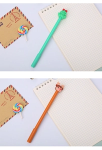 Close-up of Christmas themed pens with green tree and brown reindeer toppers on a notebook