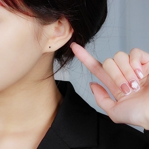 Minimalist S999 sterling silver tiny heart stud earrings on model's earlobe