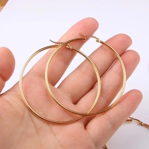Classic gold stainless steel hoop earrings for women shown in hand for scale