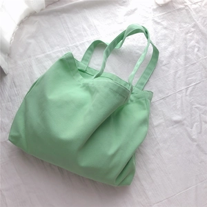 Vue de dessus d'un sac fourre-tout en toile vert menthe avec texture épaisse sur fond blanc