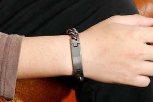 Close-up of a men's stainless steel Cuban chain bracelet with a polished ID bar on wrist