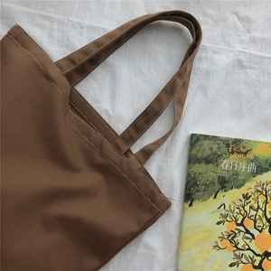 Détail d'un sac fourre-tout en toile marron foncé avec tissu épais et coutures renforcées