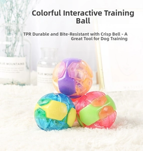 Close-up of textured TPR pet balls with built-in bells on a soft plush surface