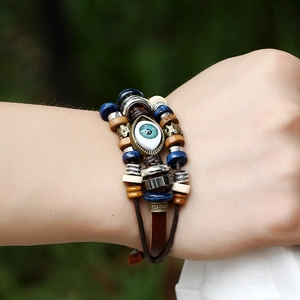 Close-up of multilayered beaded leather bracelet with evil eye charm on a person wrist
