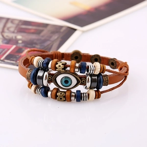 Detail of layered brown leather bracelet featuring blue evil eye bead and wood accents