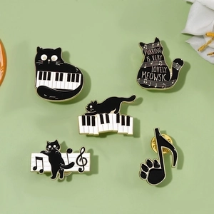 Set of 5 black cat and piano music theme enamel pins with gold finish on green backdrop
