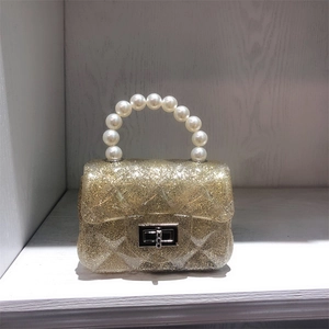 Close-up of mini PVC jelly bag featuring a glittery diamond pattern and pearl handle