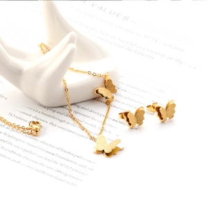 Parure bijoux papillon dorée avec collier bracelet et boucles d'oreilles sur support