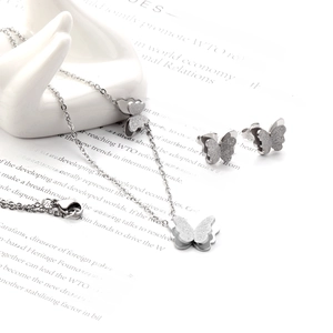 Détails d'un ensemble collier et boucles d'oreilles papillon en argent sur décor stylé