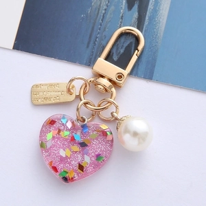 Pink heart resin keychain with silver glitter, white pearl and golden Follow your heart tag