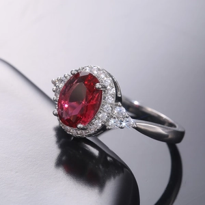 Macro shot of large oval red gemstone ring with micro-paved cubic zirconia accents