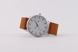 Détail du cadran blanc minimaliste avec boîtier argenté et guichet de date de montre