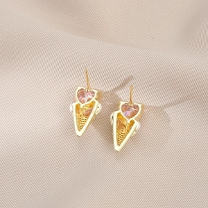 Golden heart ice cream cone stud earrings with pink zircon on soft beige fabric