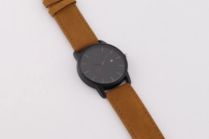 Vue détaillée d'une montre à quartz noire minimaliste avec bracelet en daim marron