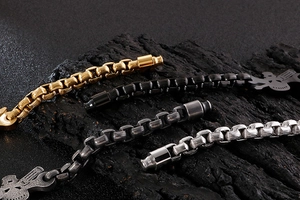 Detailed close-up of industrial box chains in gold, black, and silver with skull charms
