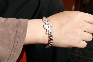 Detail of silver square box chain bracelet with punk skull and wrench pendant