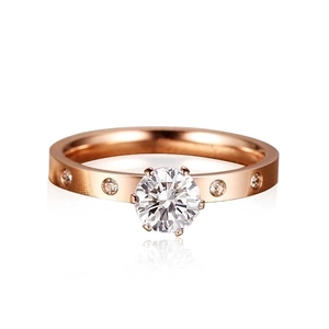 Classic six-prong solitaire rose gold ring with side stones on a white background