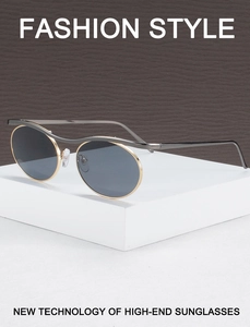 Detailed view of oval metal sunglasses with gold frames on a white display stand