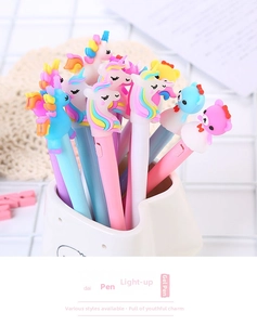 Detail view of colorful cartoon unicorn pens with LED glowing feature in white holder