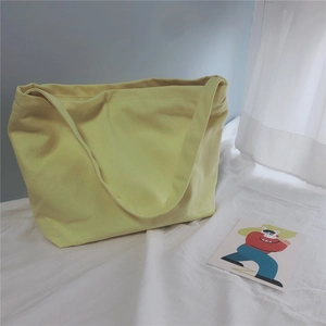 Close-up of lemon yellow canvas tote bag showing thick fabric texture and shoulder straps