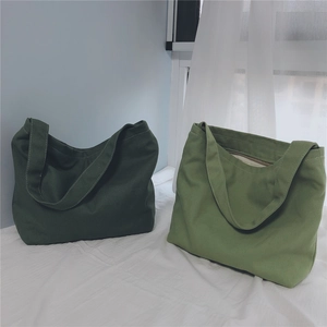 Detail of dark green and light grass green canvas tote bags with wide shoulder straps